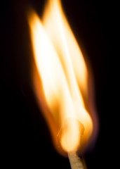 Close up burning matchstick on black background