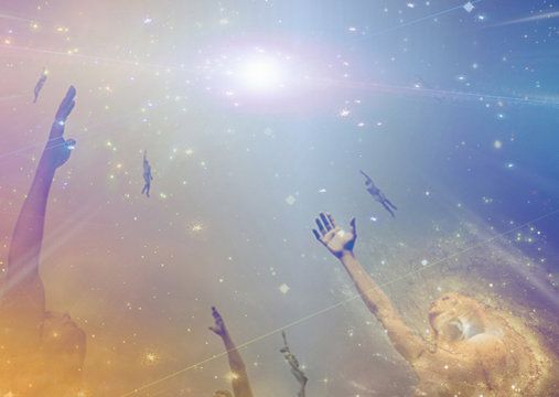 People soaring toward light amongst stars