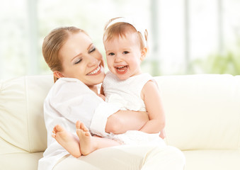 Fototapeta na wymiar happy family. Mother and baby daughter plays, hugging, kissing