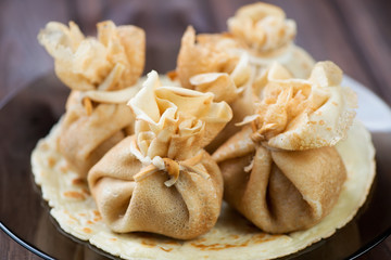 Close-up of stuffed crepes on a plate, horizontal shot