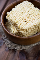 Wooden bowl with dry chinese noodles, vertical shot