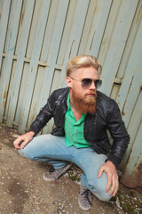 young bearded man squatting outdoor