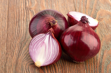 Fresh red onions on a wooden background