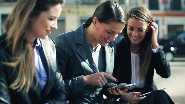 Happy group of business people watching something on smartphone