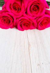 bunch of rose on white wooden surface