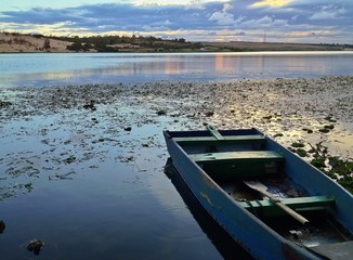 Obraz premium Solitary Boat at Sunset at Lotus Lake, White Sand Dunes, Vietnam