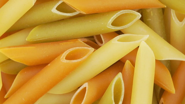 Loopable background of uncooked Italian macaroni pasta.