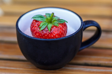 Strawberry in a cup of dessert on bamboo table