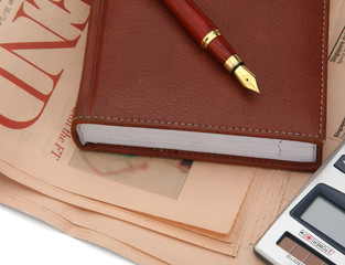 A diary and a fountain pen placed on a financial newspaper