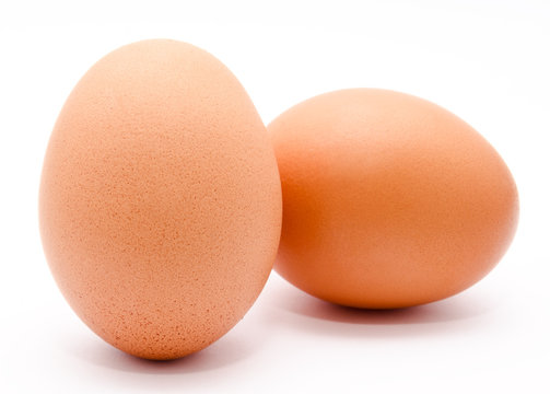 Two brown chicken eggs isolated on a white background