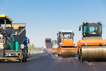 Road rollers, tracked paver and truck during road works