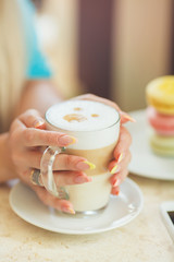 A hot Cup of coffee latte with colorful sculpture cookies
