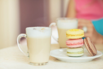 A hot Cup of coffee latte with colorful sculpture cookies