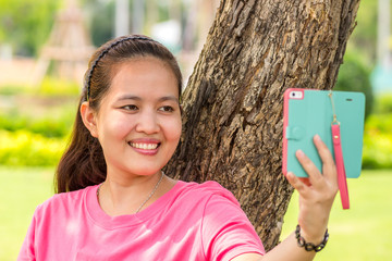 Asian woman using smart phone in the park.