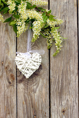 Białe serce na drewnianym tle w otoczeniu kwiatów - obrazy, fototapety, plakaty