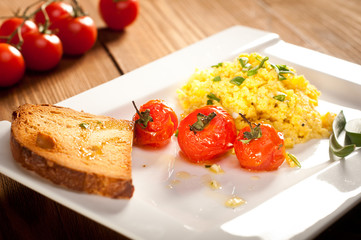 Scrambled eggs with roasted cherry tomatoes, toast and chive
