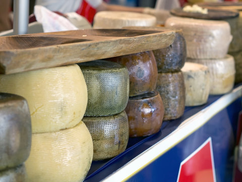 forms of italian pecorino cheese on a table in a fair