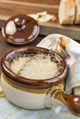 Traditional crock full of French Onion Soup with melted Gruyere