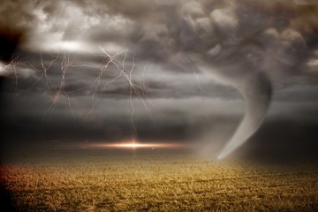 Stormy sky with tornado over field