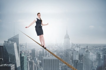 Composite image of businesswoman doing a balancing act