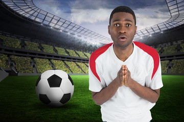 Composite image of nervous football fan in white looking ahead