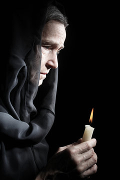 Senior Woman With Candle In Sadness