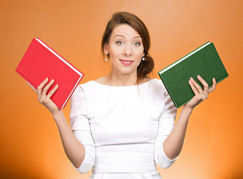 Which book? Confused student woman uncertain what to read