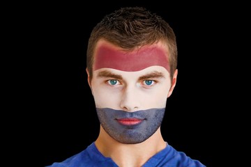 Composite image of serious young netherlands fan with facepaint