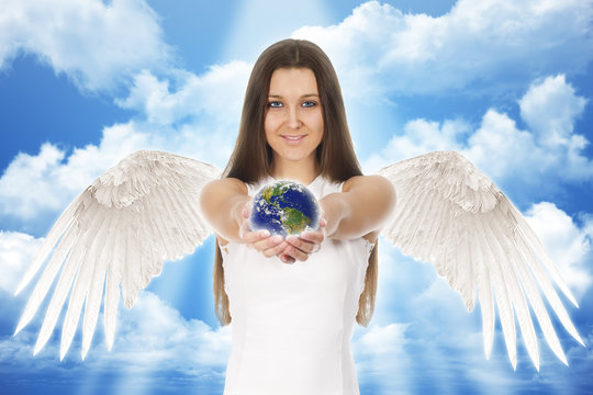 beautiful young angel woman holding Earth in hands with clouds