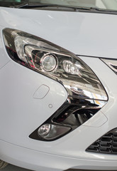 Car headlamp. Part of car at dealership salon.