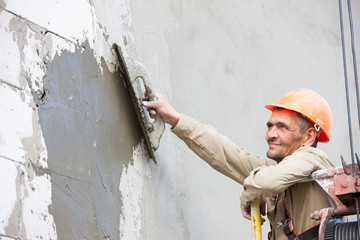 Plastering multi storey building wall of concrete blocks