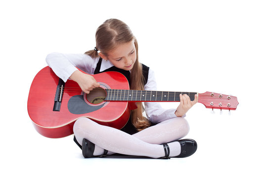 Little girl with red guitar, sitting
