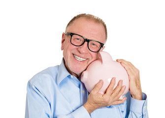 Savings in old age. Happy senior man holding piggy bank