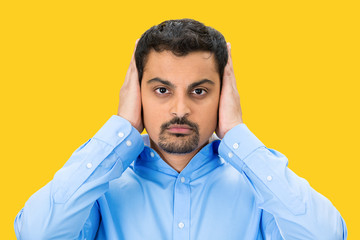 Obraz premium Hear no evil concept. Man covers his ears, yellow background 