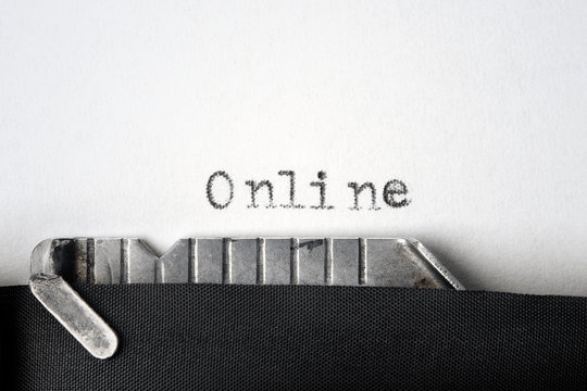 "Online" written on an old typewriter. Closeup.