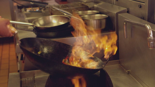 Chef tossing flaming stir fry