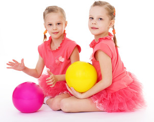 Fototapeta premium Two charming sisters love to play ball.