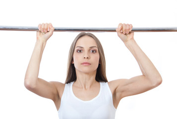 woman exercising on pull-up bar
