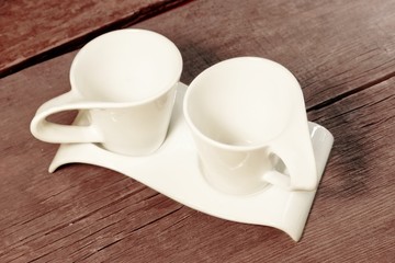 Fototapeta na wymiar Two Vintage White Cups on Grungy Wooden Table. XXXL