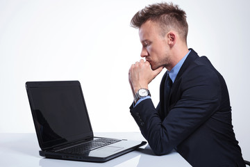 business man looks pensively at laptop