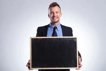 business man holds a small chalkboard