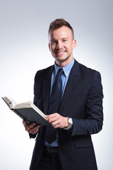 business man smiles with book in hand