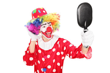 Male clown looking in a mirror
