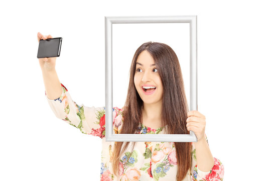 Woman Taking A Selfie Behind A Picture Frame
