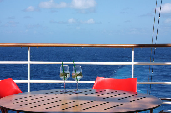 Zwei Gläser Sekt auf dem Deck eines Kreuzfahrtschiffes mit Blick auf das blaue Meer