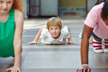 Kinder machen Liegestütze im Sportunterricht