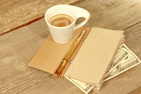 Open Vintage Notepad, Gold  Pen, Hundred doolar and Cup of Espre