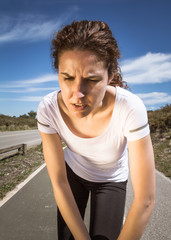 Tired runner girl sweating after running with sun