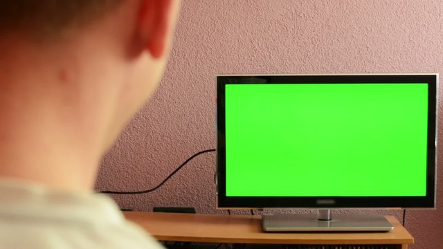 Man watches TV(television) - green screen - man laughs