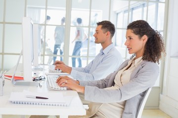 Casual pregnant businesswoman working at desk